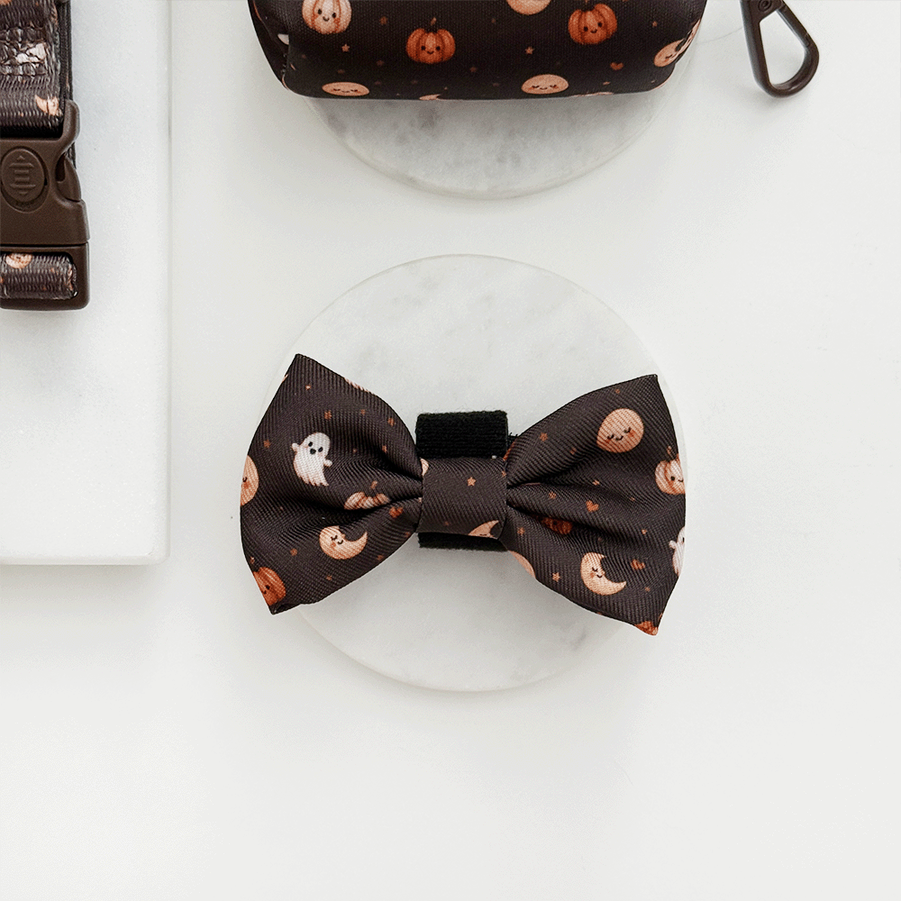 Brown dog bow tie with cute Halloween print featuring pumpkins, ghosts, and moons.