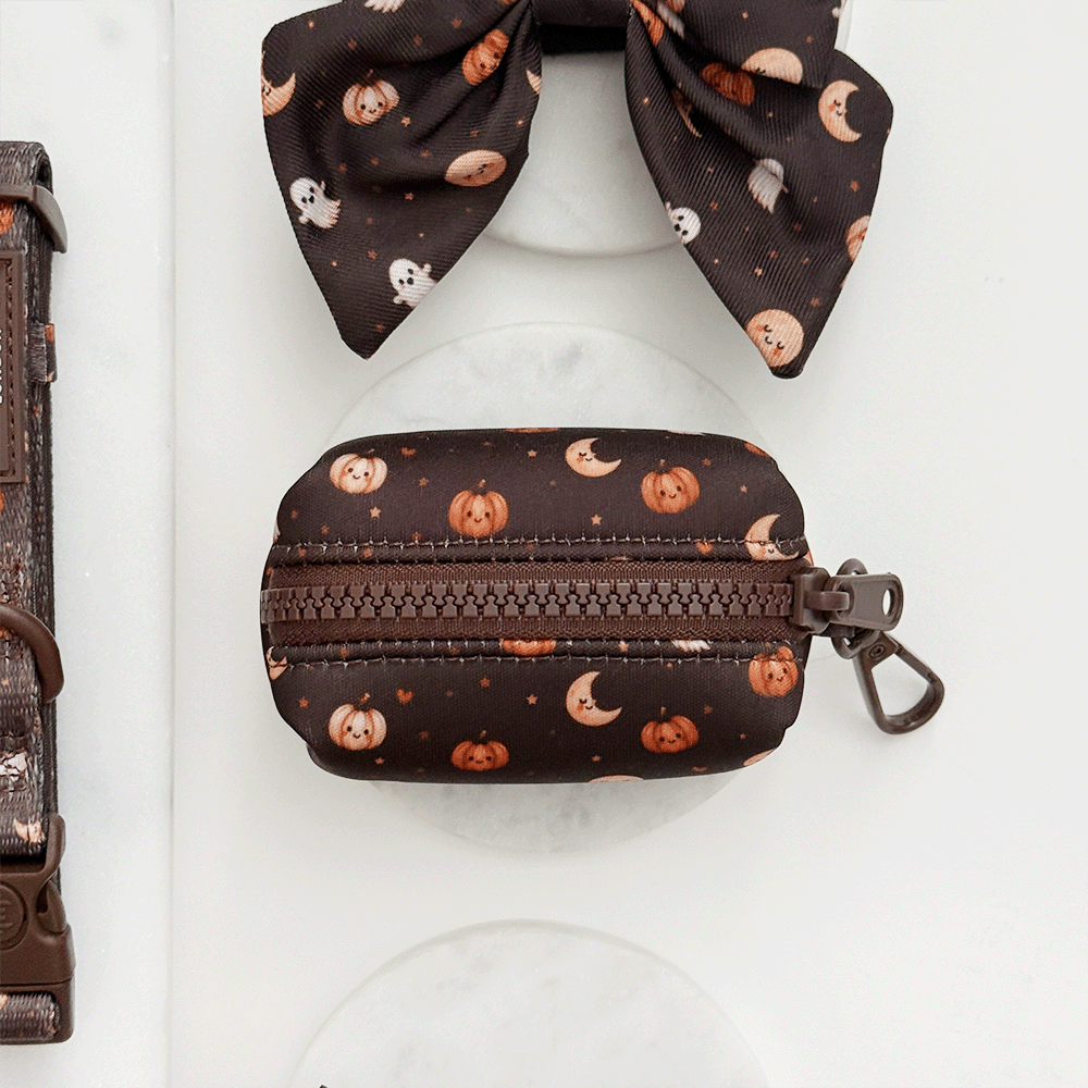 Brown poop bag holder, to hold dog poo bags, with cute Halloween print featuring pumpkins, ghosts, and moons.