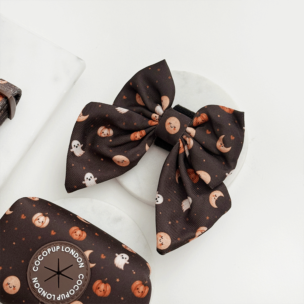 Brown dog sailor bow tie with cute Halloween print featuring pumpkins, ghosts, and moons.