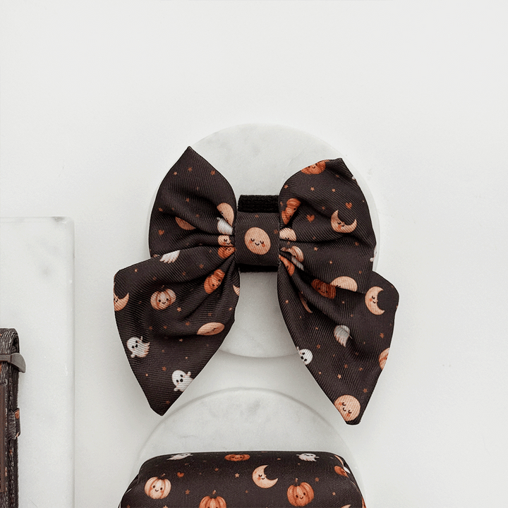 Brown dog sailor bow tie with cute Halloween print featuring pumpkins, ghosts, and moons.