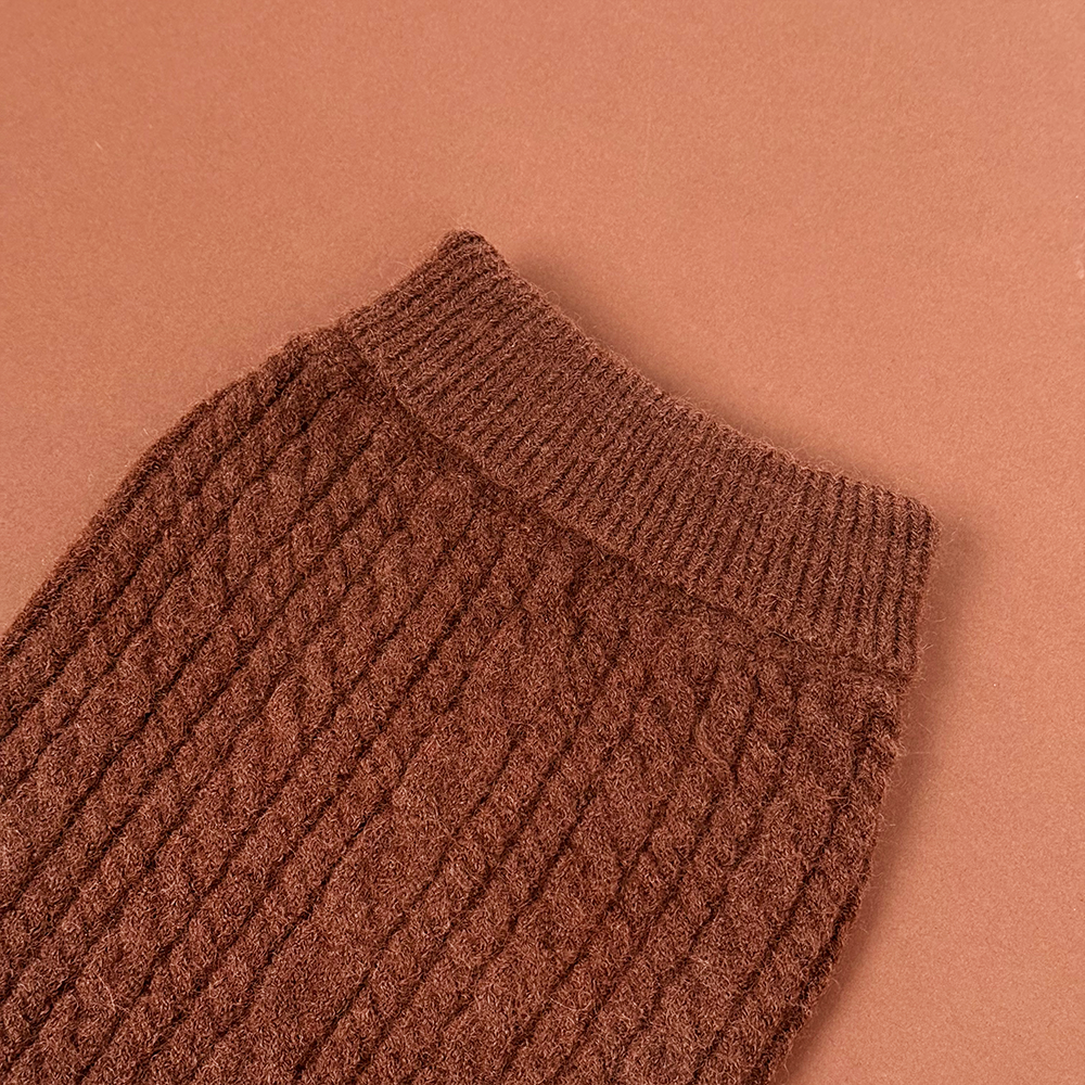 Brown cable knit jumper sleeve with ribbed texture and cuff detail.