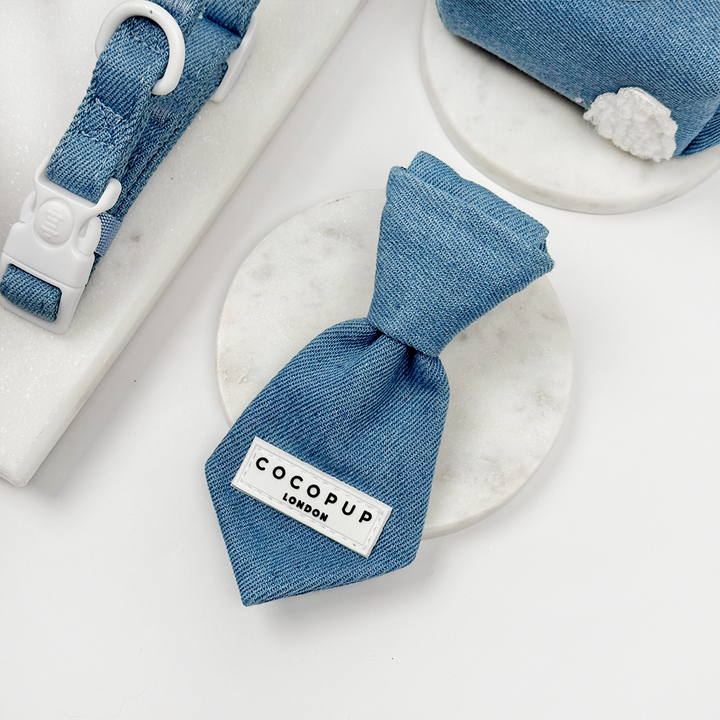 Blue denim dog tie with a Cocopup label on a white background