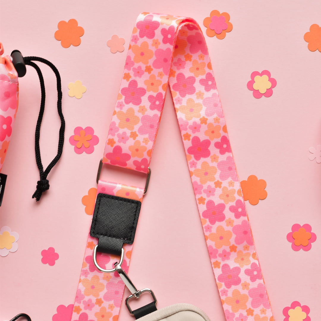 Pink floral bag strap by Cocopup London with a vibrant summer bloom pattern and paper flower accents.