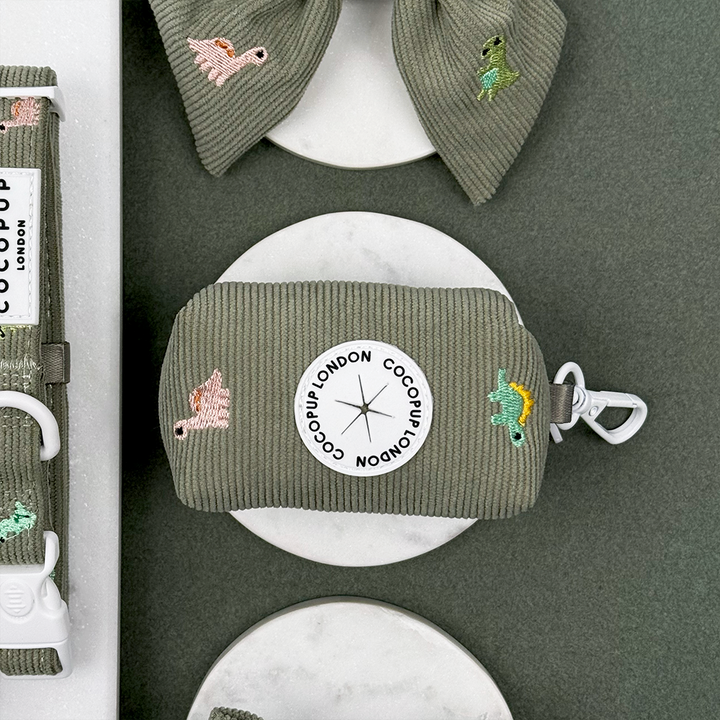 Green corduroy material Dog Poop Bag Holder with embroidered dinosaurs. 