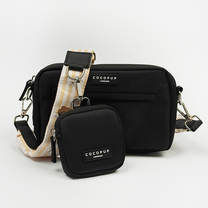 Cocopup black Dog Walking Bag with pale yellow and white striped Bag Strap with bee and honeycomb embroidered decals. Attached is a Cocopup Treat Pouch in black.
