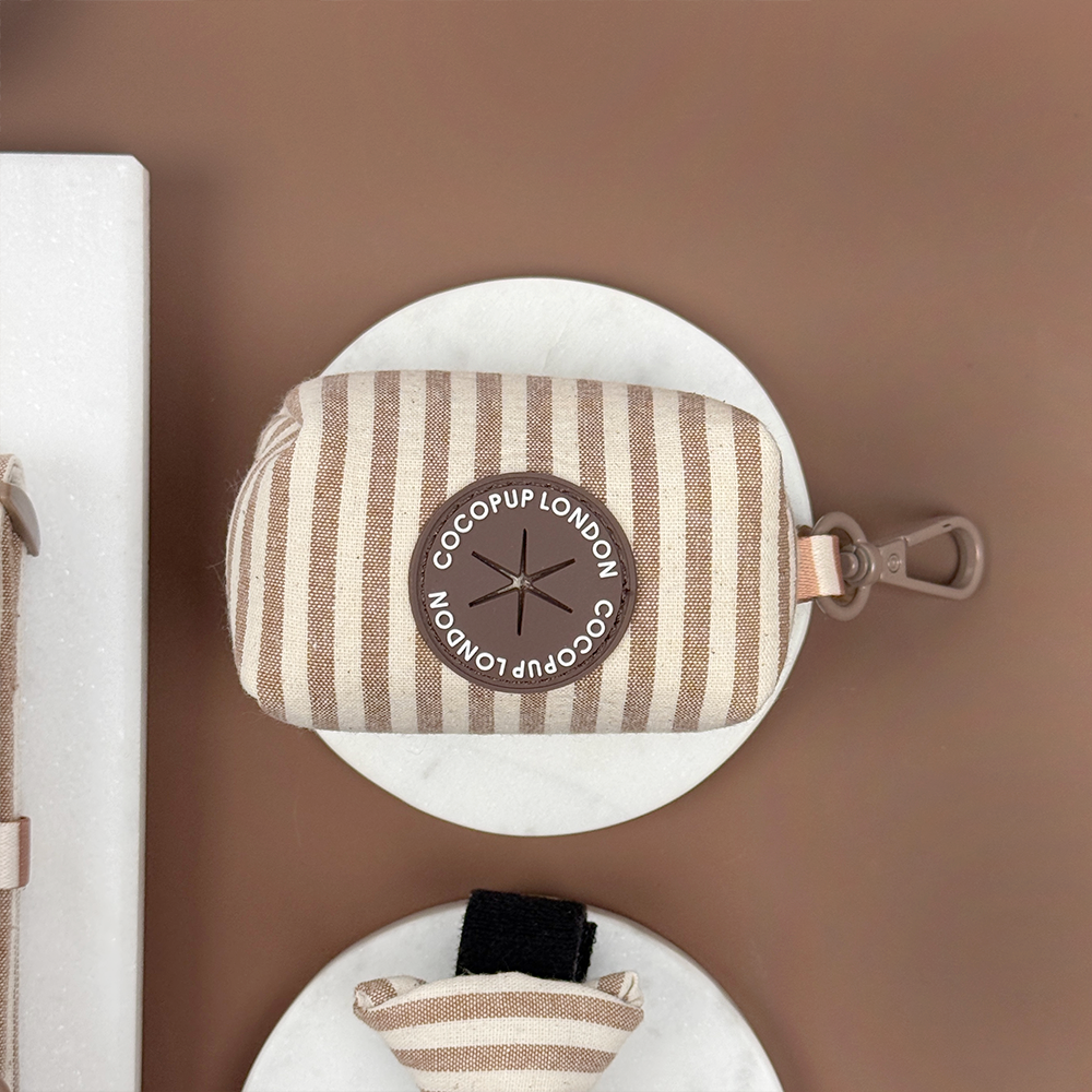 Brown and beige striped pouch with a hole to put poop bags through. 