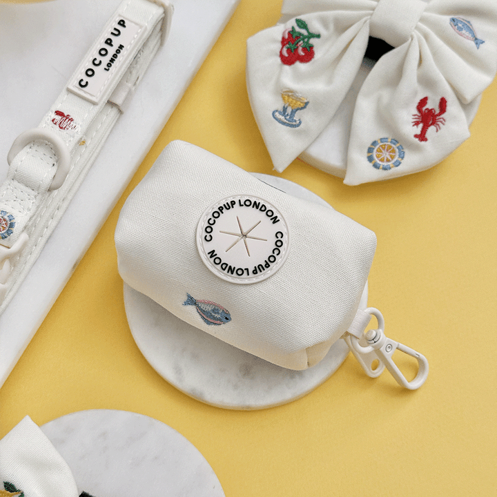 White linen fabric Dog Poop Bag Holder with summer embroidered embellishments.