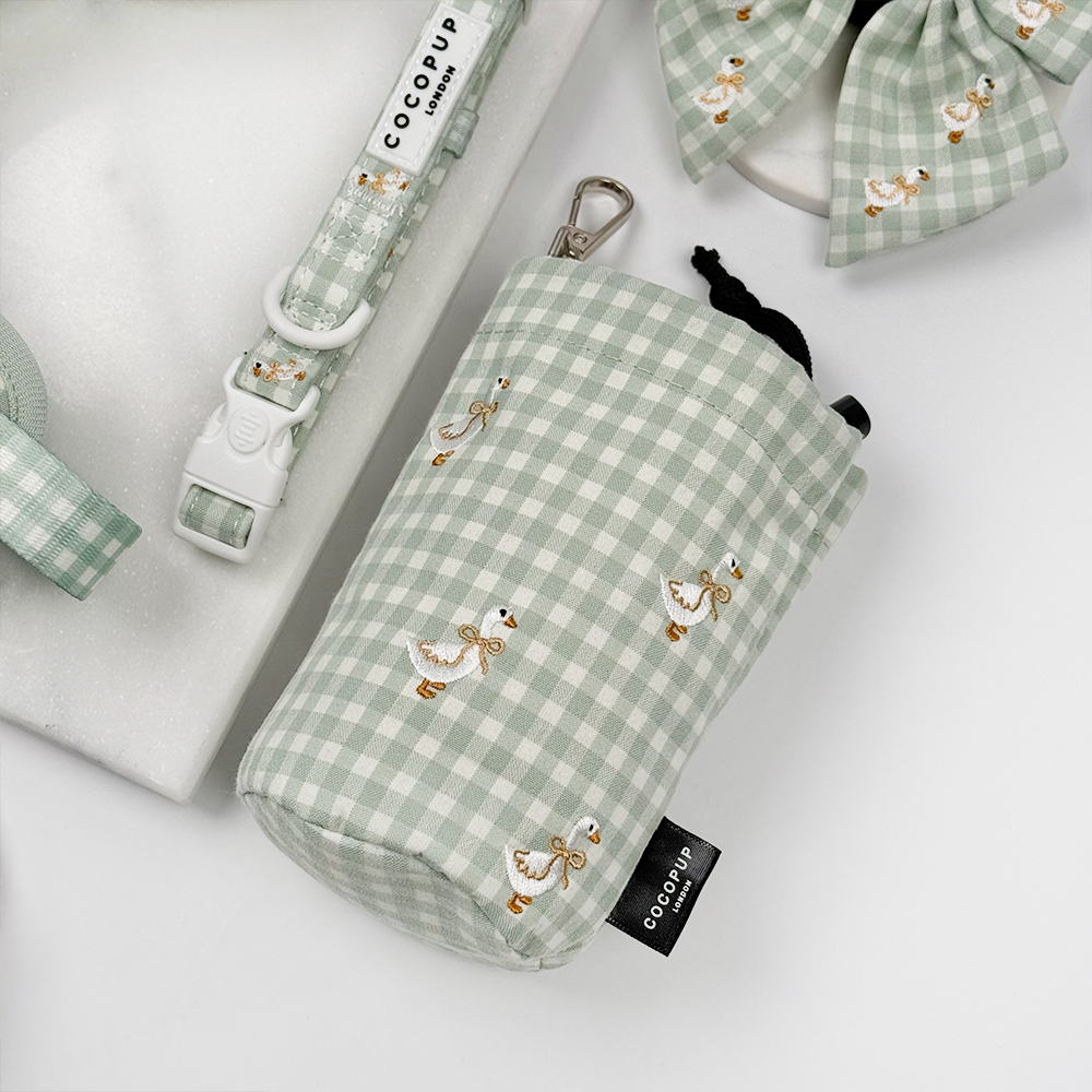 Green and white check print drawstring treat pouch for dogs with embroidered geese design.